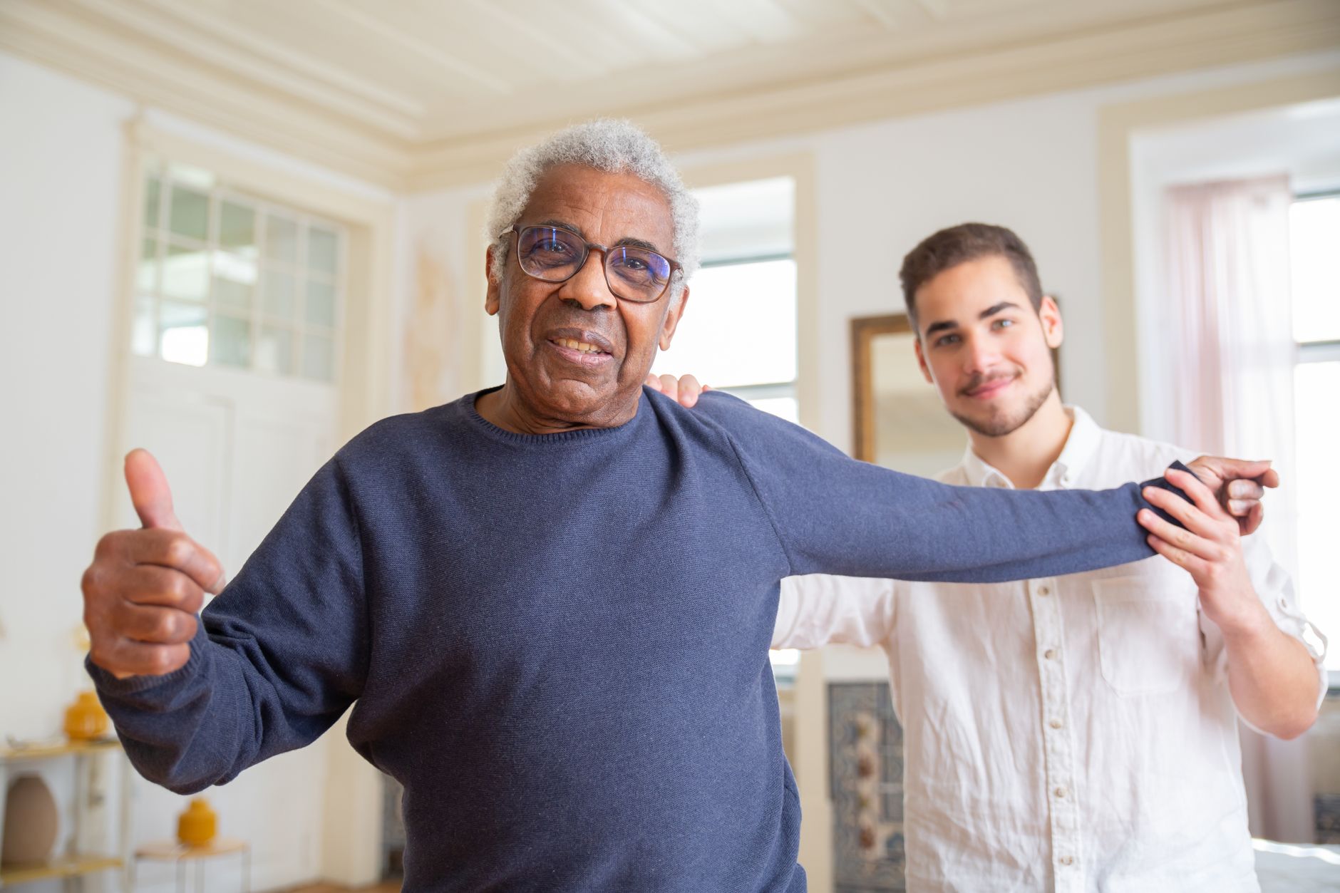 A caregiver and an elderly man sharing a warm moment at home