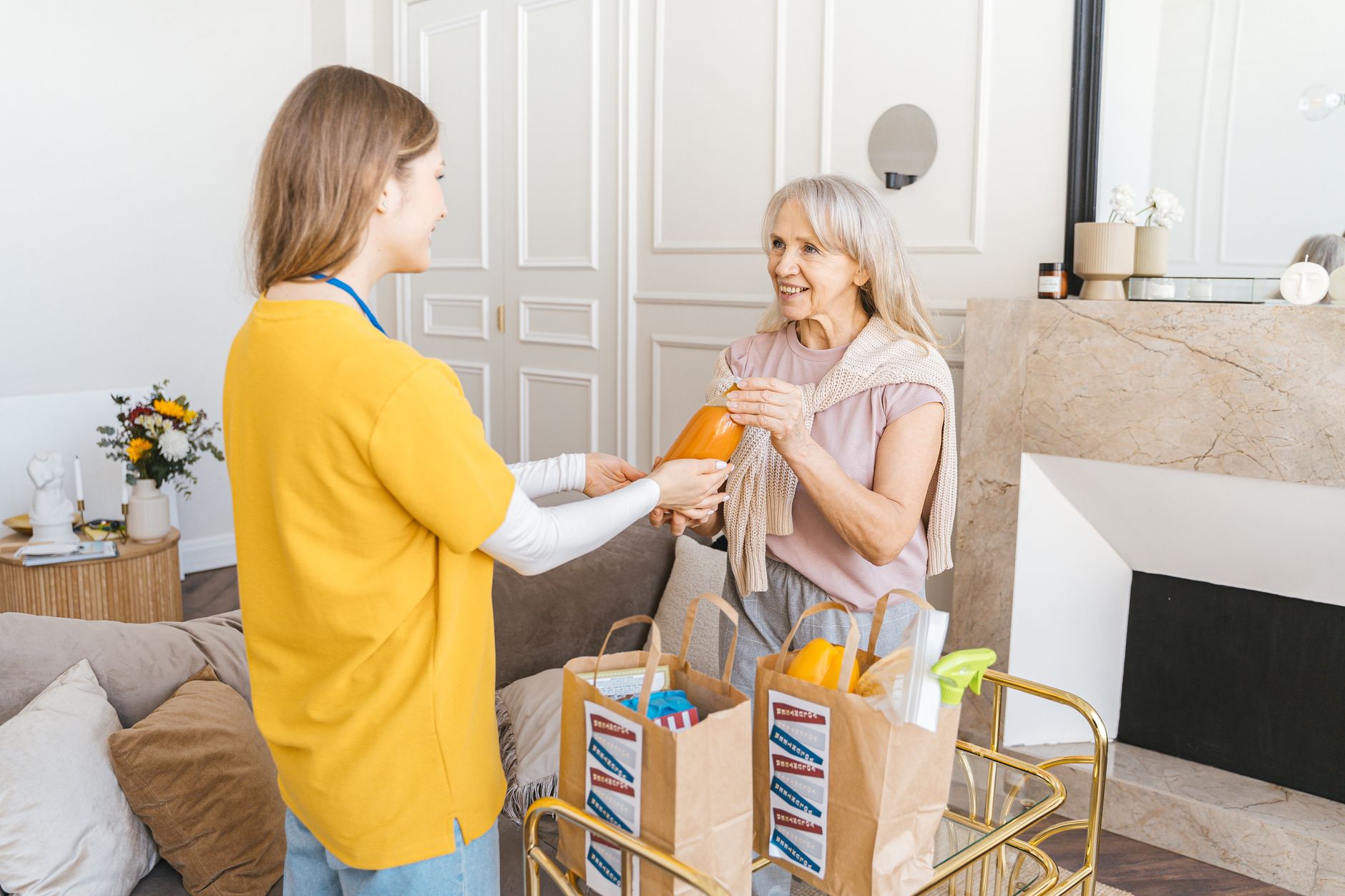 A caregiver warmly assisting an elderly woman at home